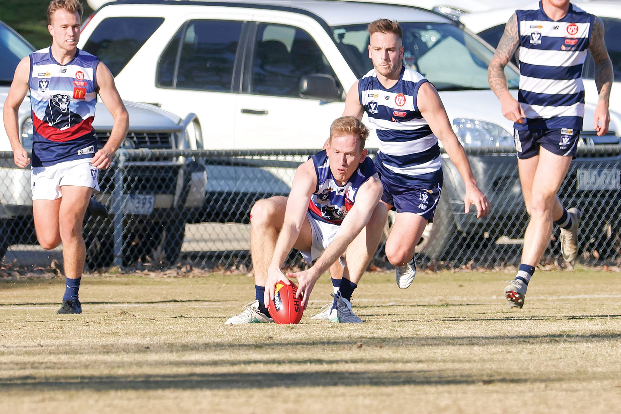 Tall defender, Sam Watson goes all the way down to trap the Sherrin.