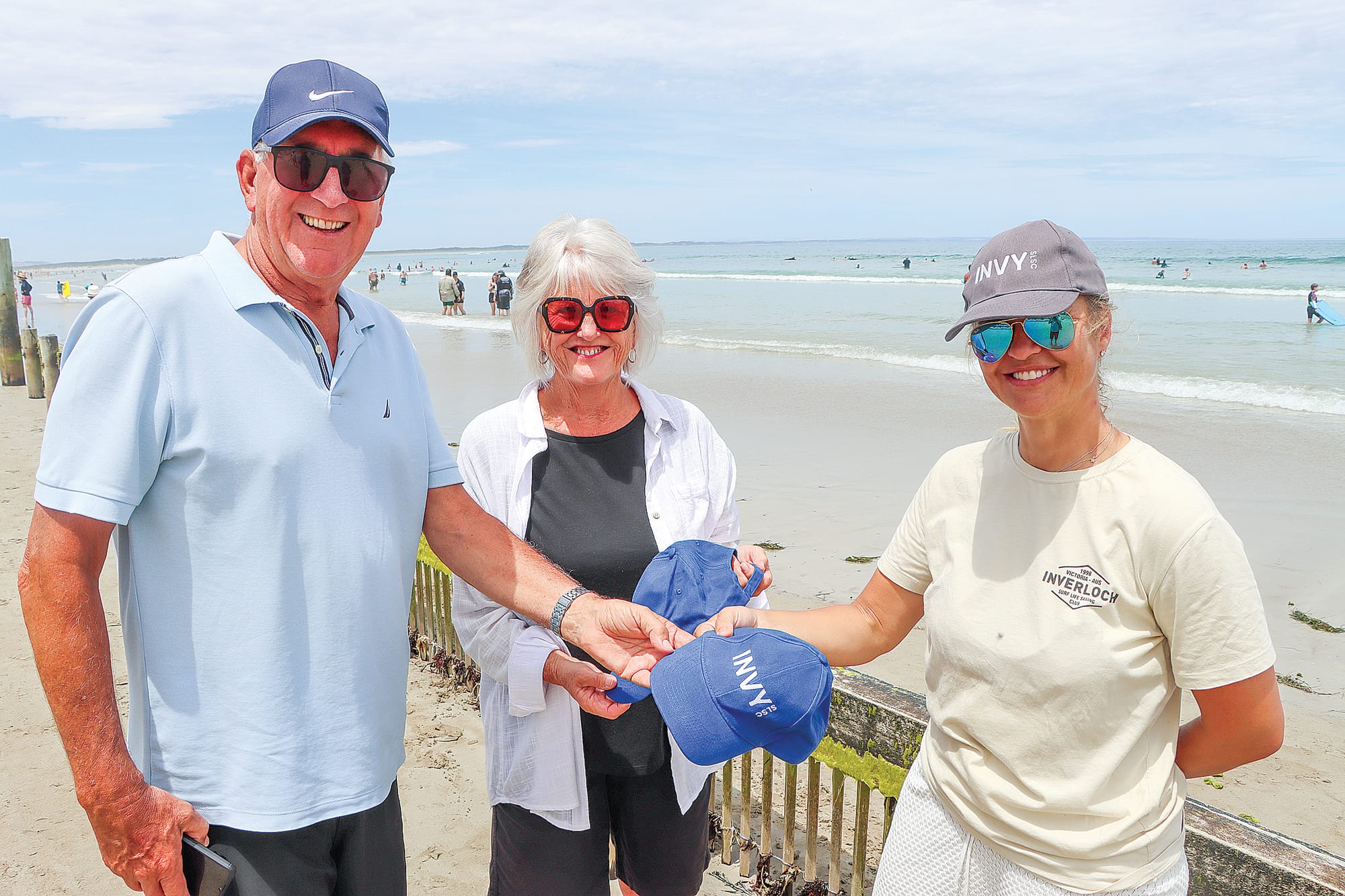 Ian and Helen Davis are given Invy Surf Life Saving Club caps by Simone O’Donohue. A04_0125