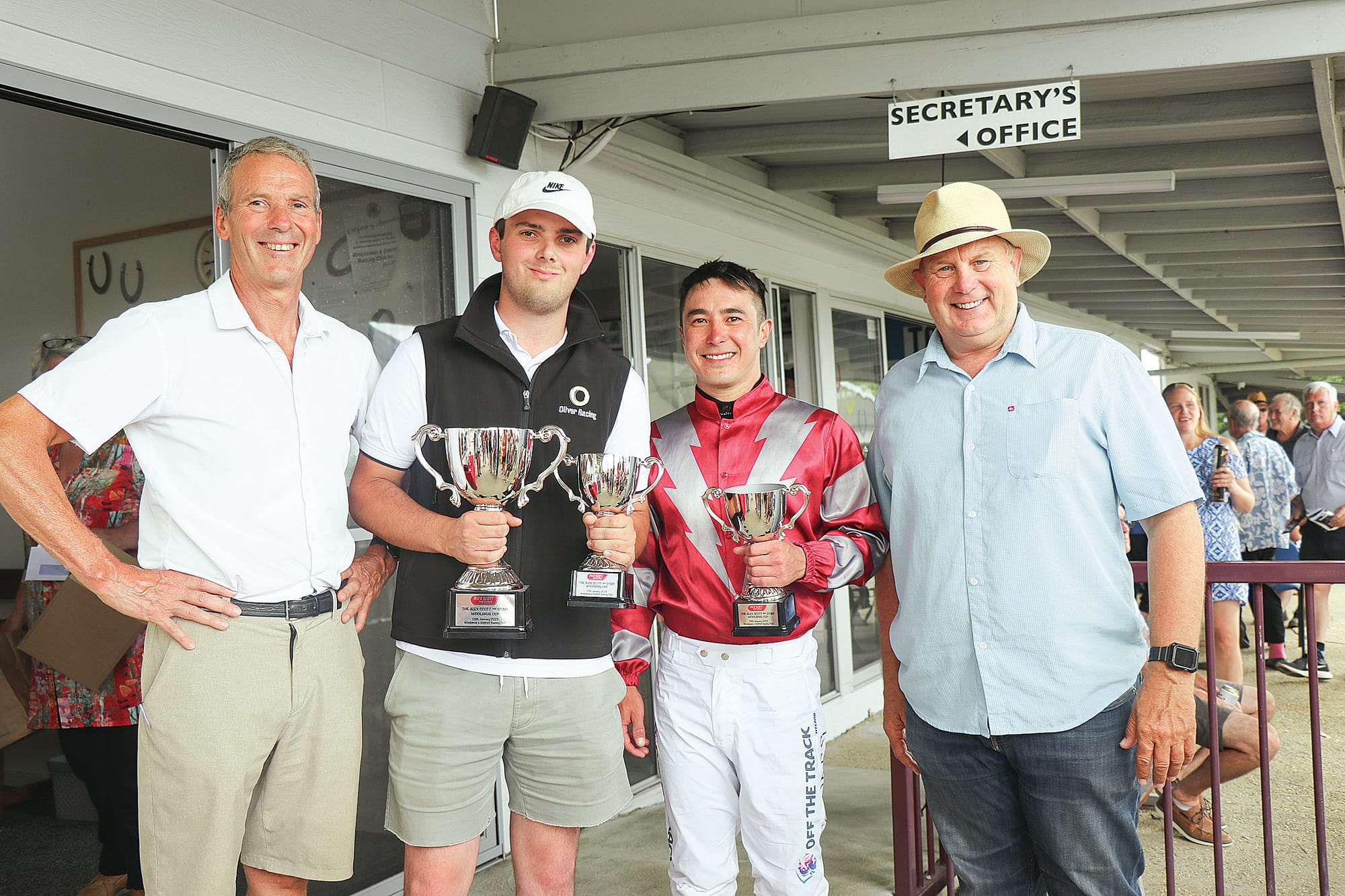 Smiles all round as winning trainer Lachlan Cormick and jockey Shaun Cooper accept their 2023 Woolamai cup trophies from race sponsors Tom Gibson and Greg Price of Alex Scott & Staff. Z22_0523
