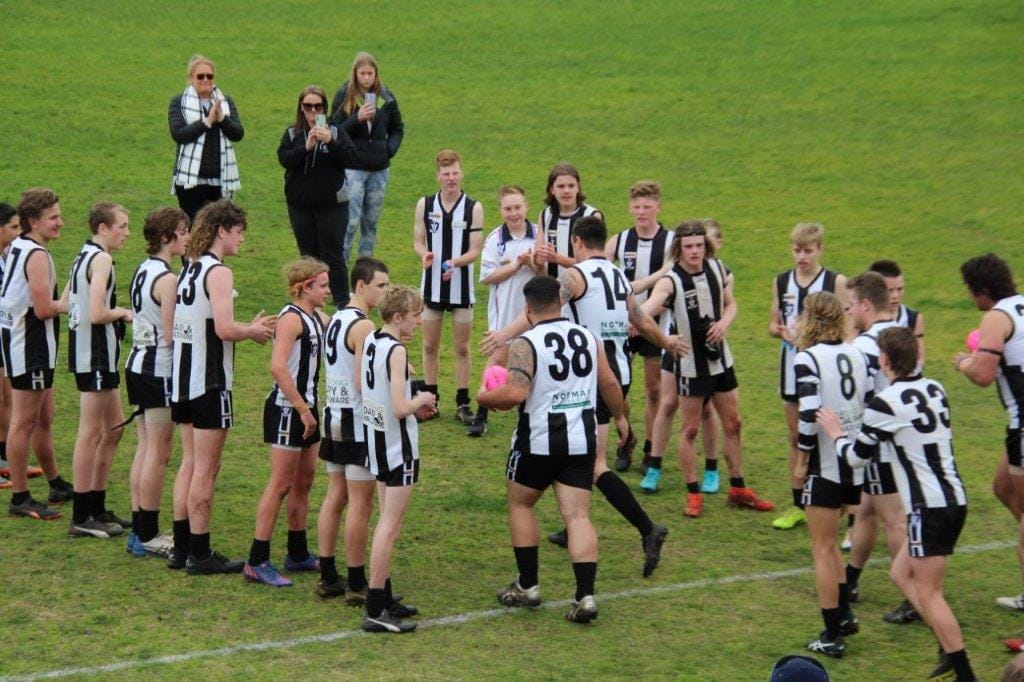 Poowong Fourths players provide a guard of honour as Jake Peacock, wearing his brother Noah's Number 8, takes the field in his memory last Saturday against the Lang Lang Reserves.