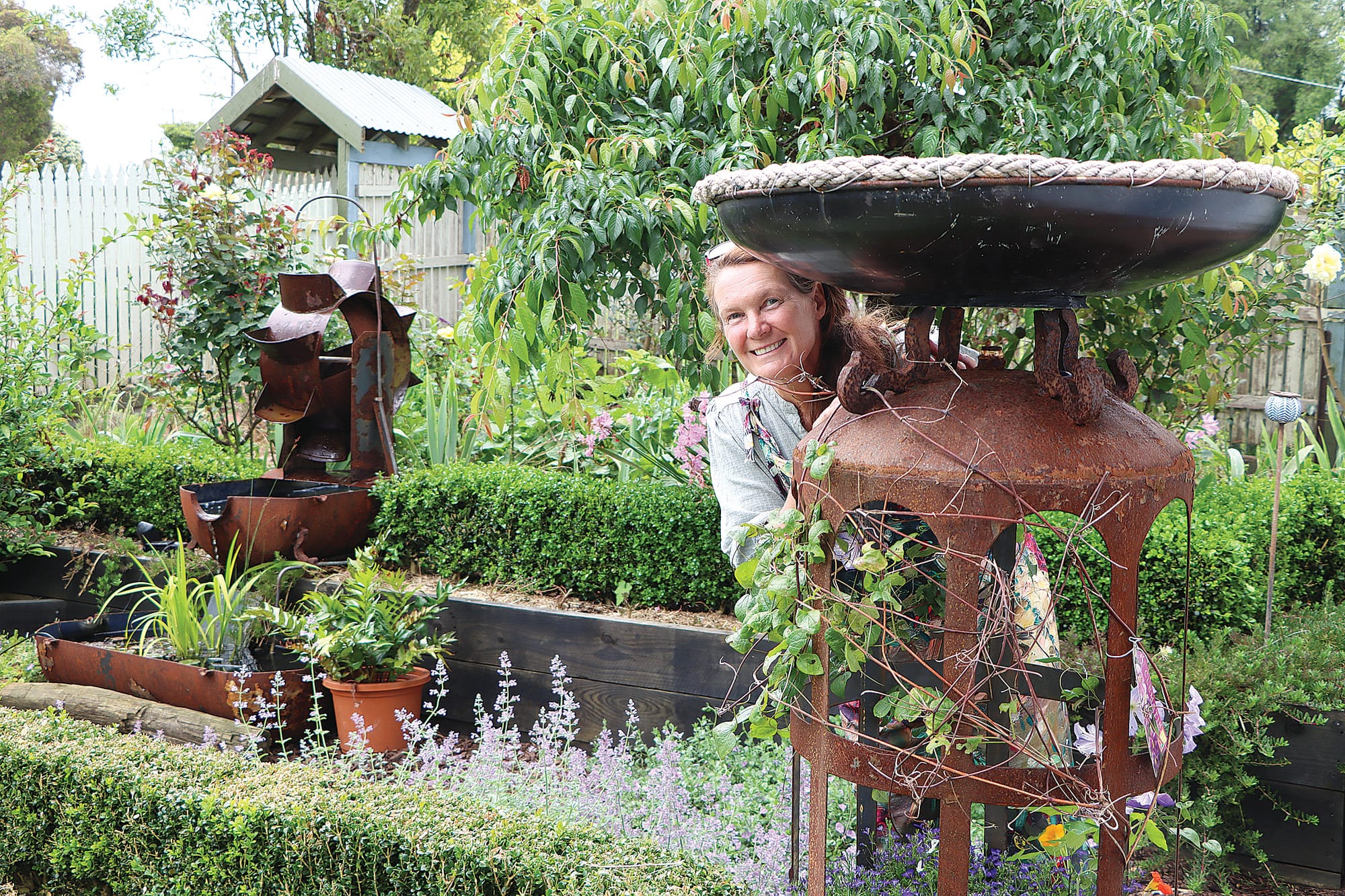 Fiona Bilbrough in her garden with a piece made from an old hot water service. A34_4924