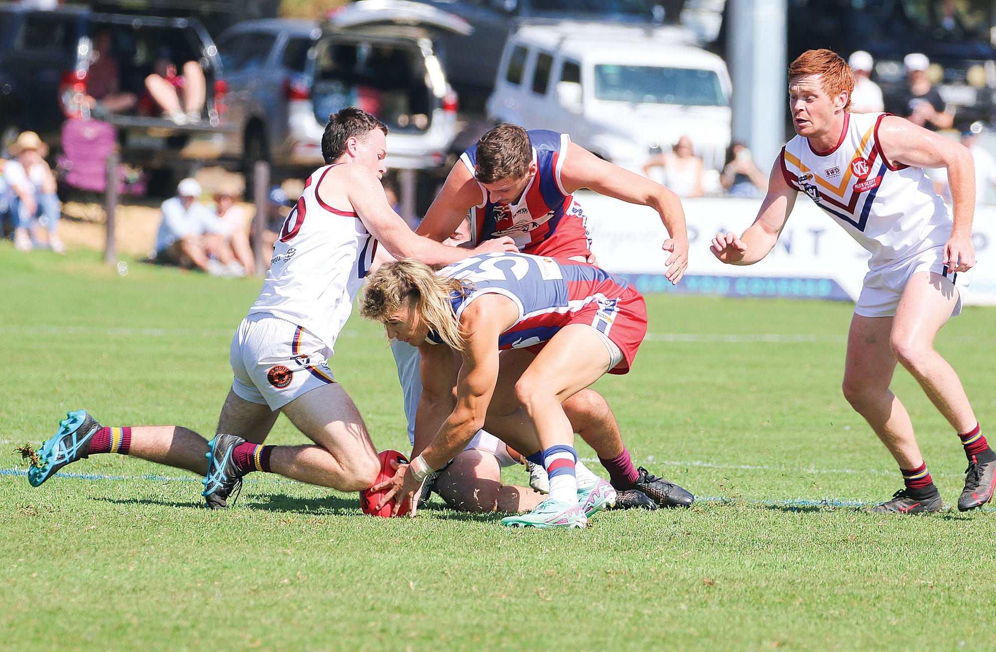 Phillip Island’s Thomas Baulch protects the ball from his Dusties opponent.