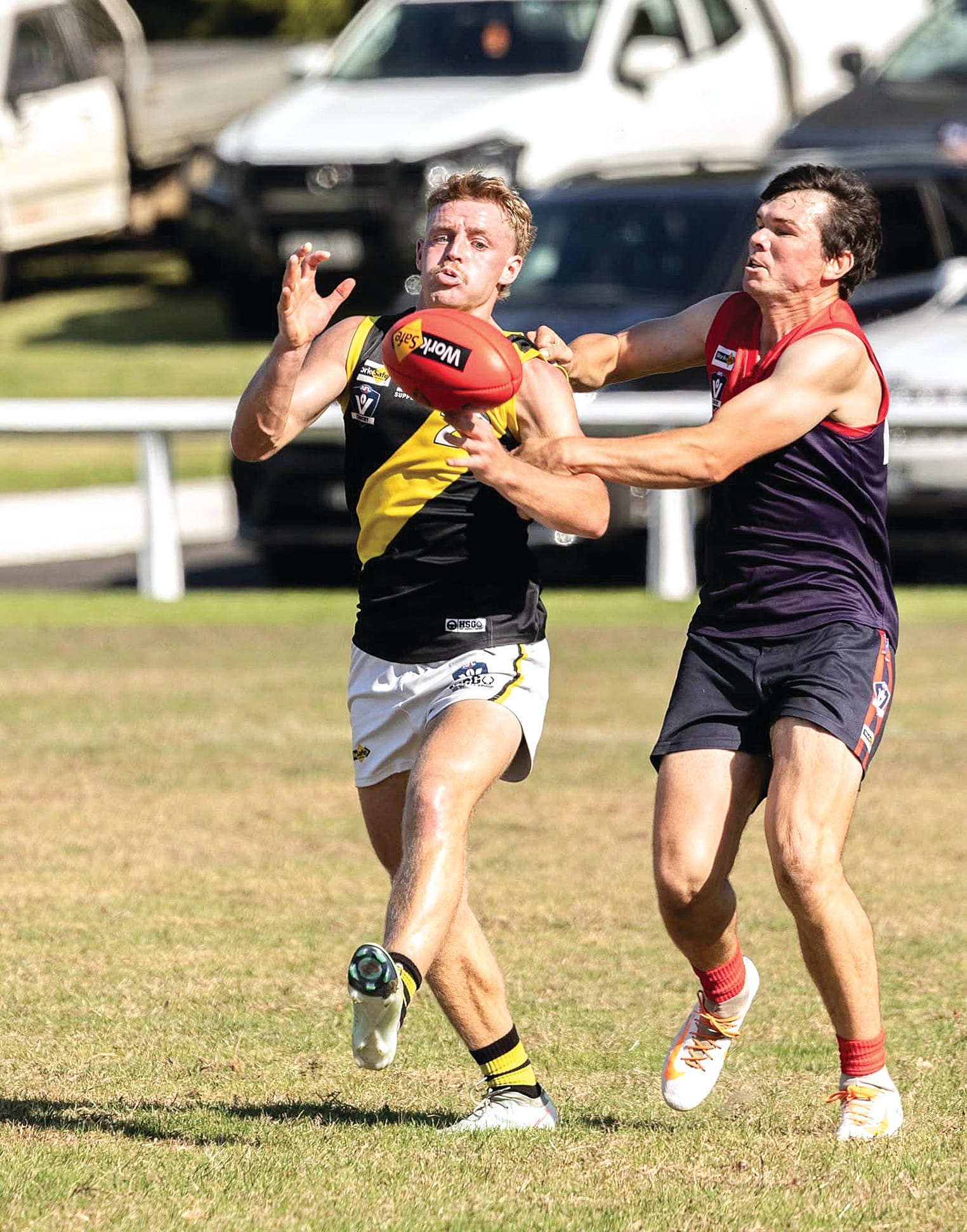 Harry Mahoney keeps focused as his demons opponent attempts a tackle. Photo: Annie Holland.