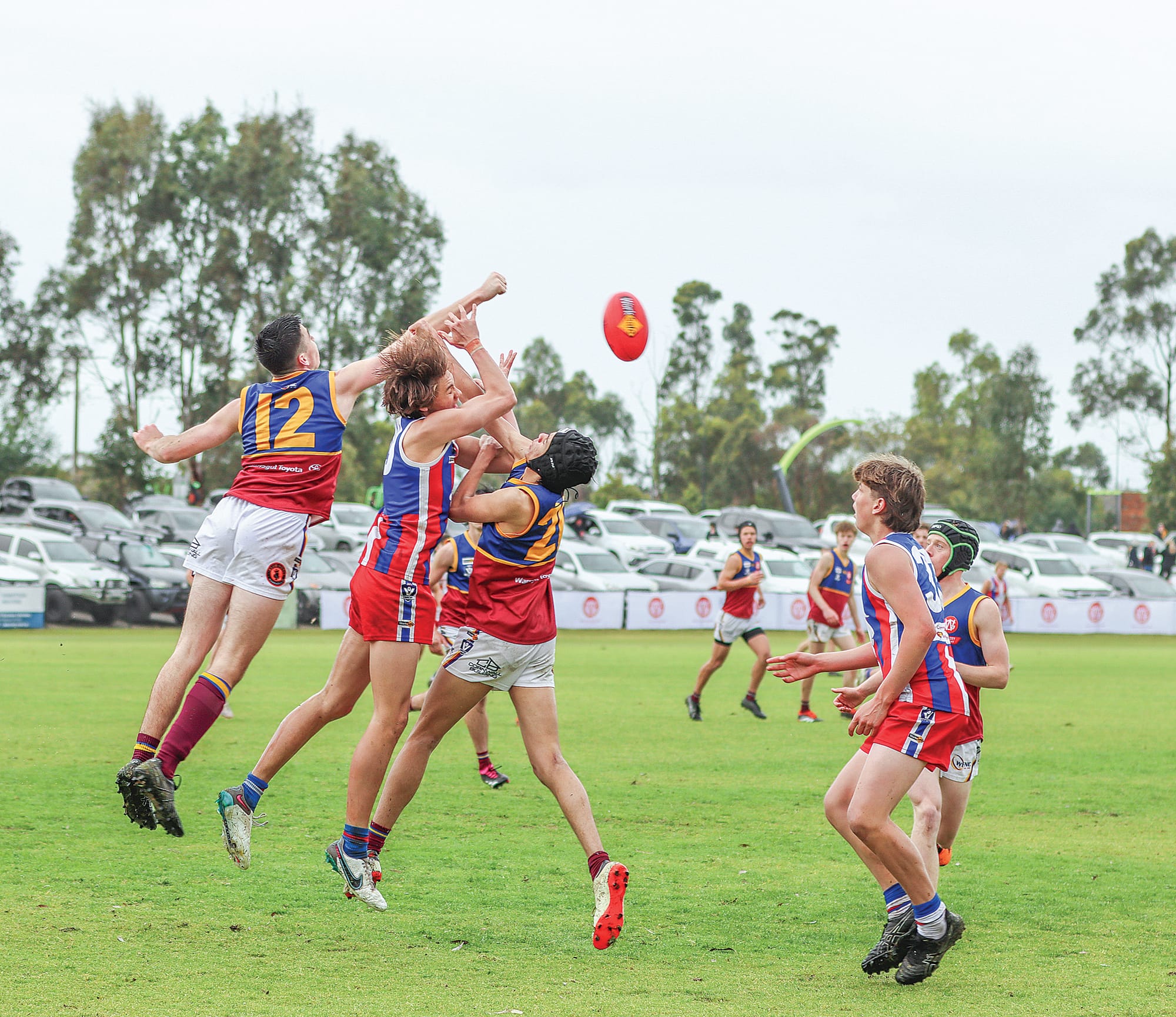 Phillip Island’s Noah Forrest Mabilia is sandwiched between Industrials Joshua Bradley and Benjamin Allsop. A31_3824