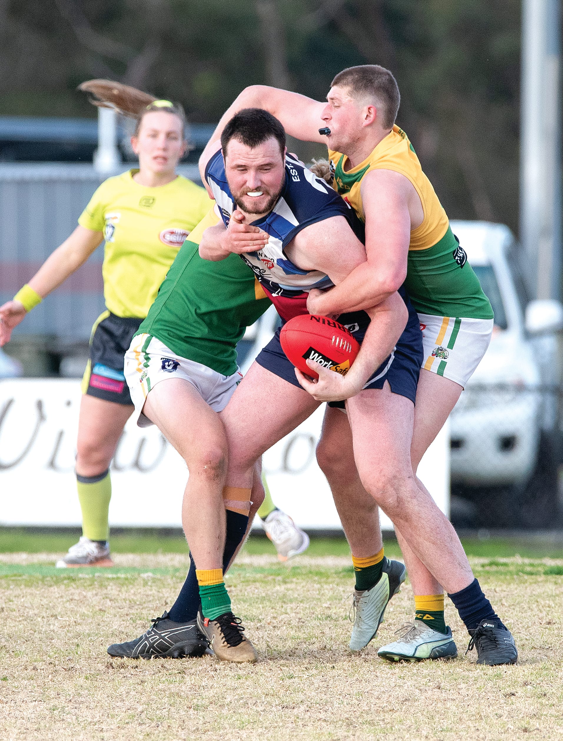 Ned Bradley looks for options as two Garfield opponents close in with the tackle.