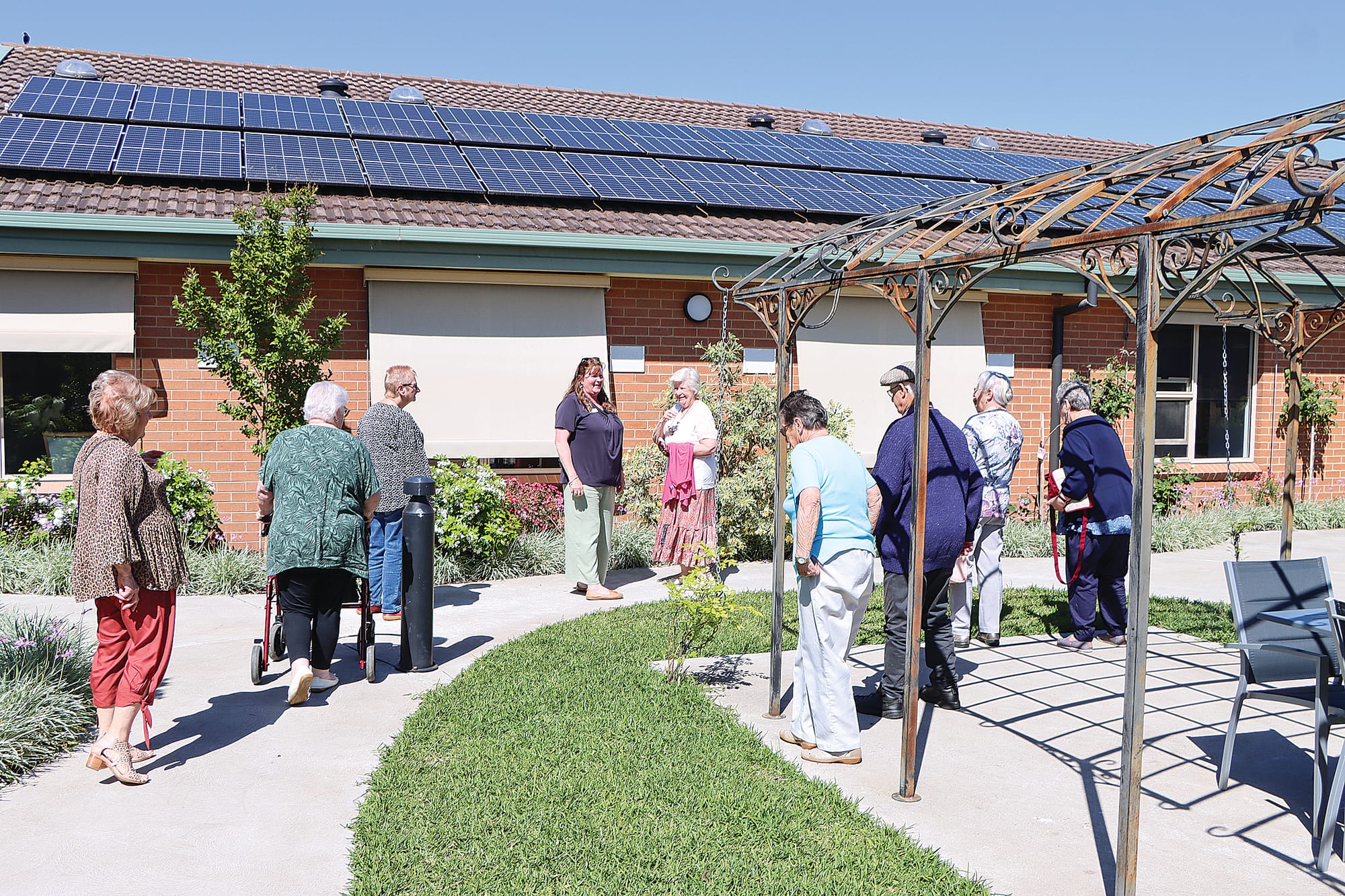 A tour group led by resident liaison officer Lyn Mayo explores the new courtyard at Carinya Lodge.