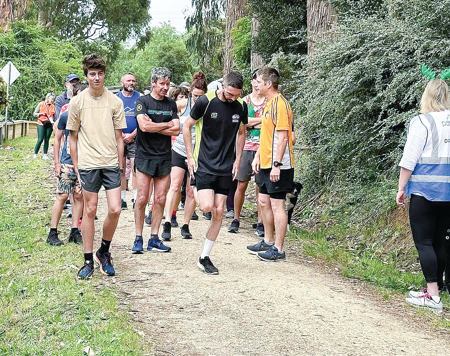 Parkrun participants await the beginning of the run at the starting line.