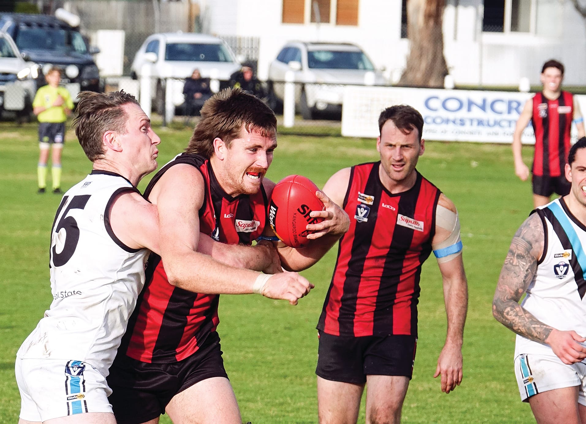 Wonthaggi’s Aiden Lindsay wraps up Maffra’s big ruckman Will Pleming as he tries to break clear of the pack