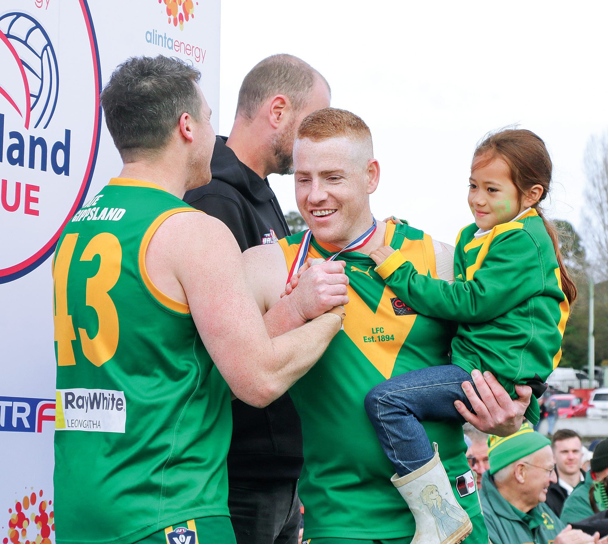 Grant Fleming receives his premiership medal after the Reserves grand final with daughter Marlee.