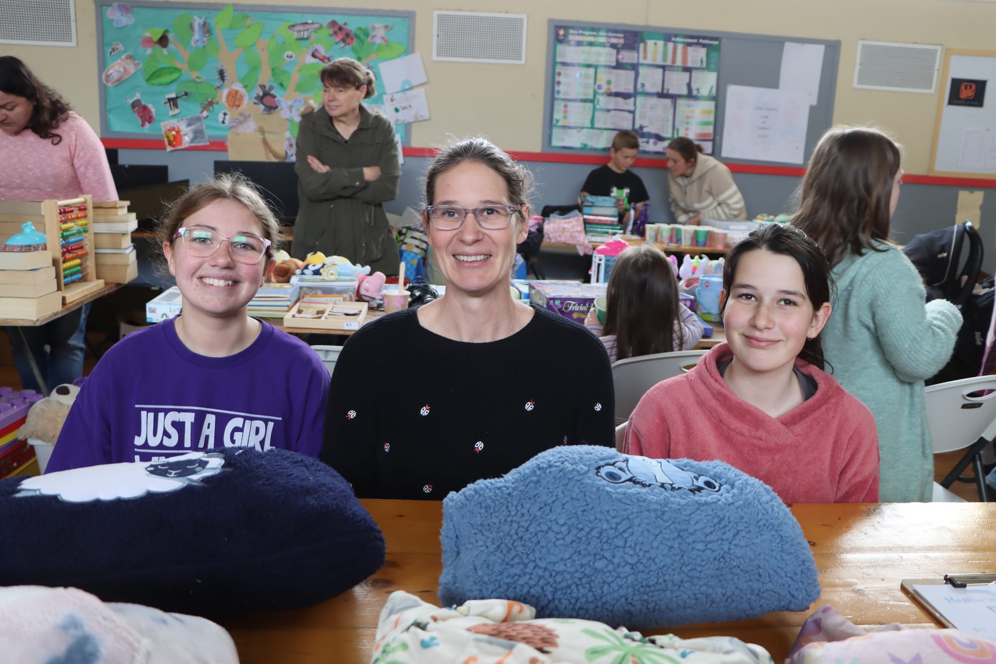 Amy Pearce, and Lauren and Lyla Martin enjoy helping run the Mega Garage Sale on Friday.