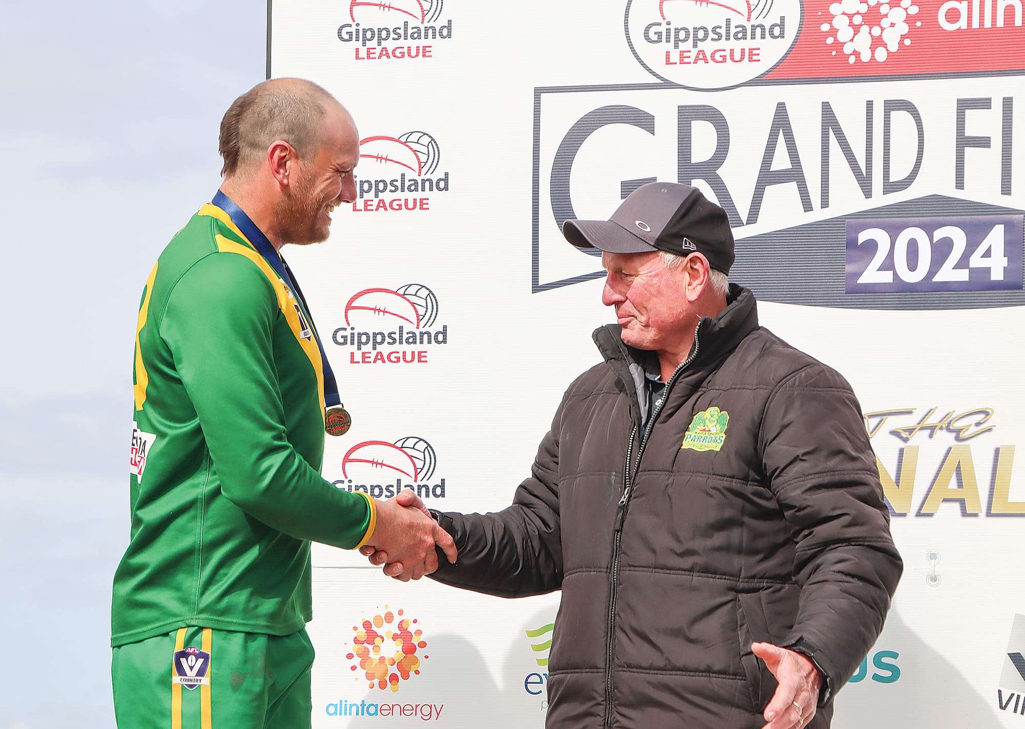 Proud dad John Schelling shakes hands with Best on Ground Josh Schelling after presenting him with his medal following Leongatha’s Reserves premiership. A60_3924