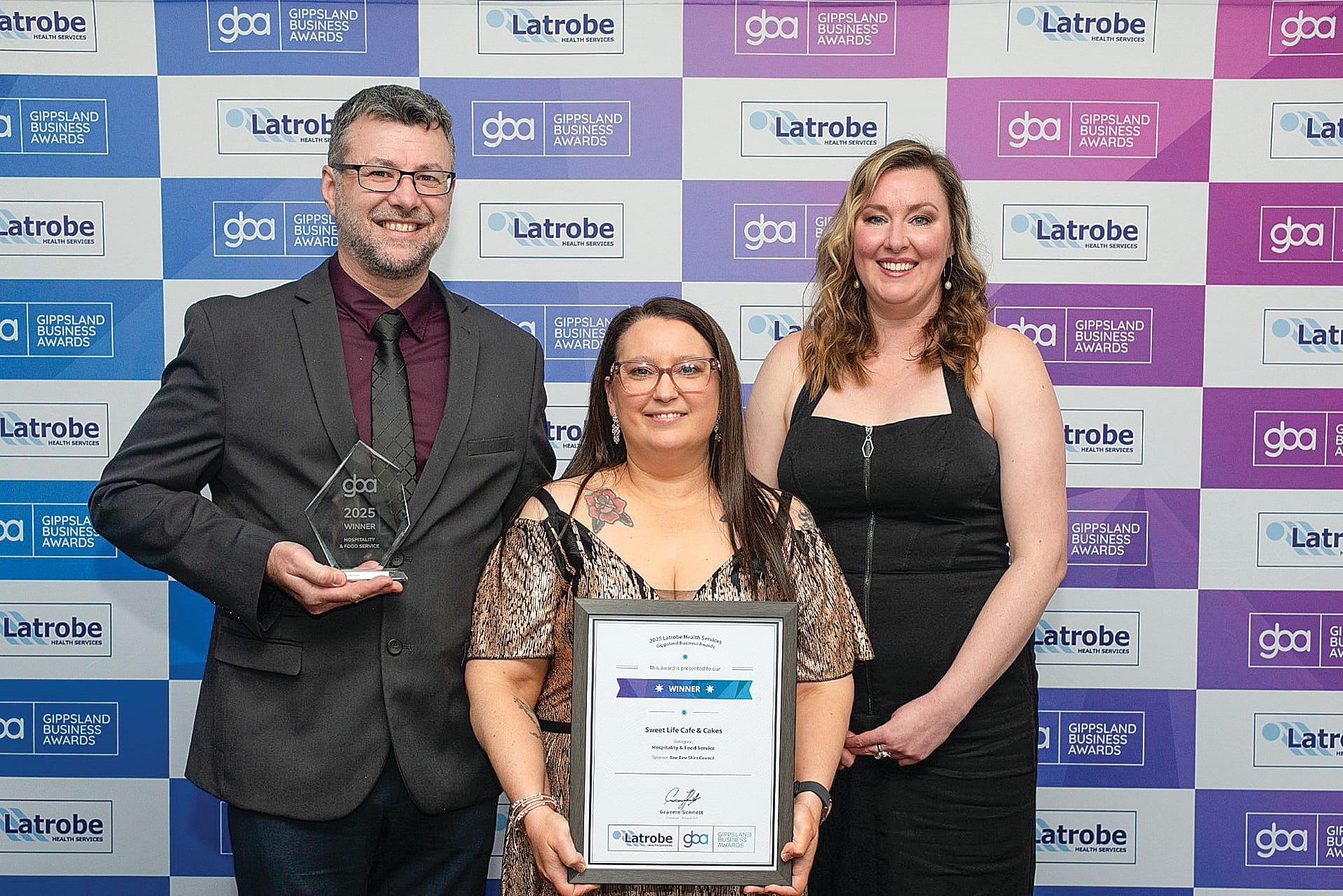 Krystal Barr from Baw Baw Shire Council (right) is pictured presenting Geoff and Jodie Clarkson from Sweet Life Café and Cakes with their award.