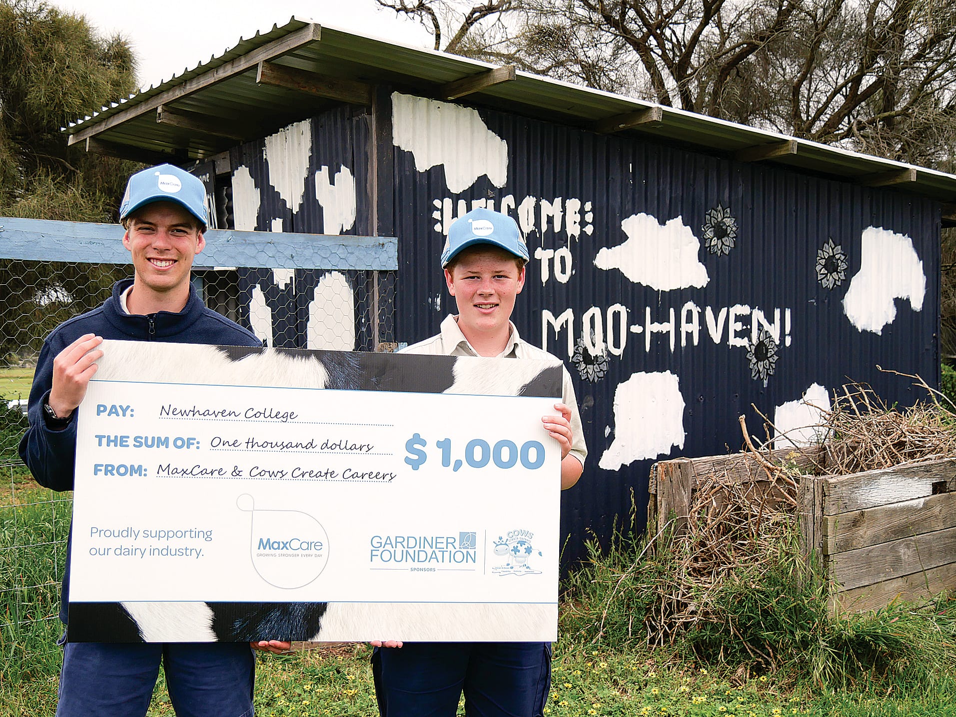 Mitch White and Riley Lawrence proudly hold the cheque for $1,000 awarded to Newhaven College for their ad design.