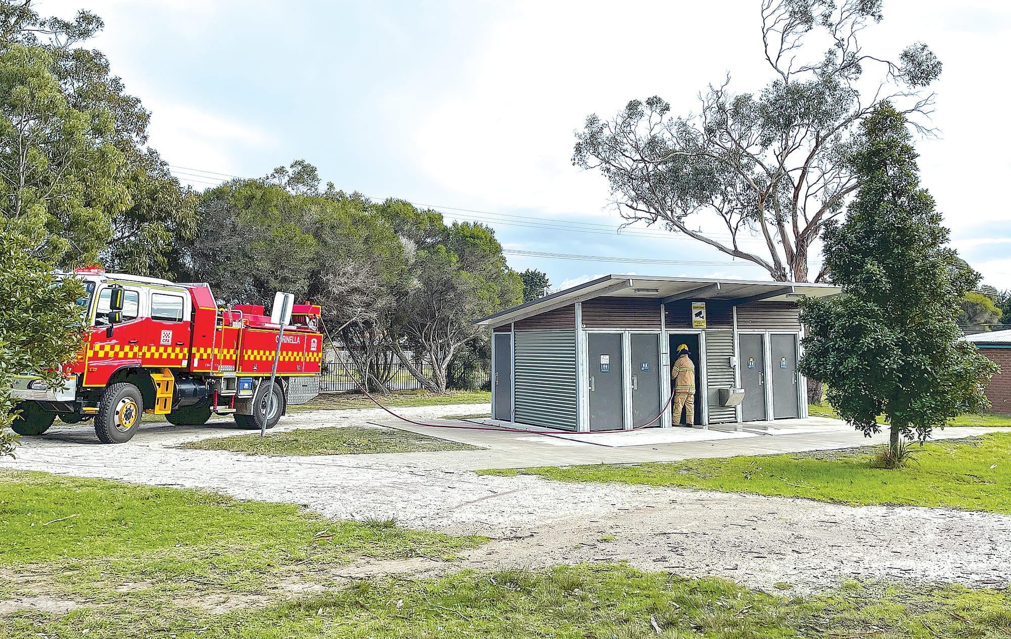 Within minutes of a 000 call, Corinella CFA member, Mick Hamilton, was putting out a deliberately lit fire in the toilet block at the Harold Hughes Reserve in the centre of Corinella. Photo: Meryl Tobin.

