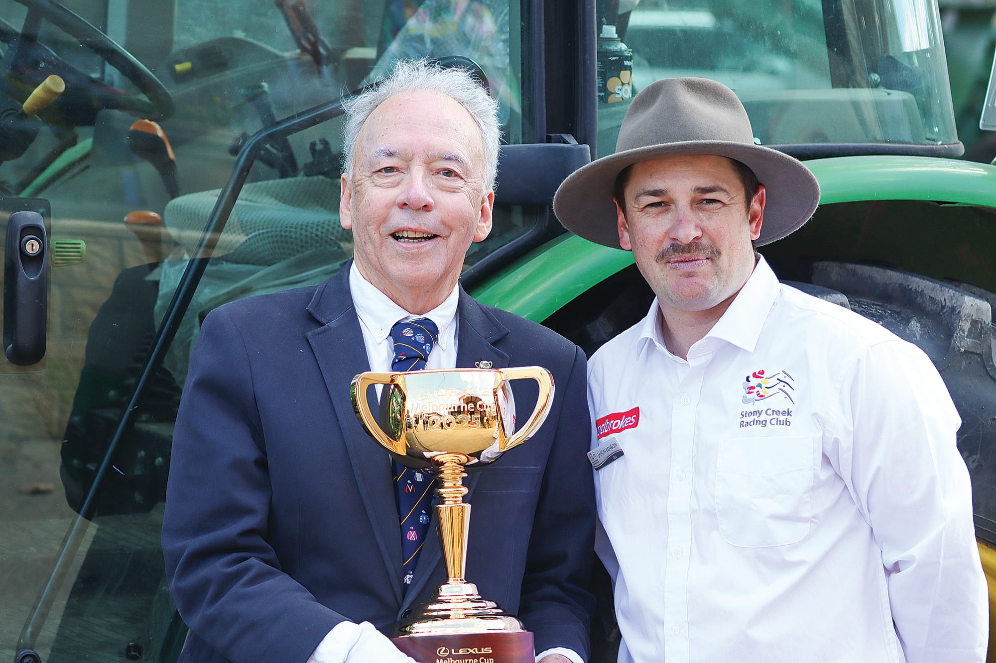 Andrew Lemon and Jason Benbow are ready to share the Melbourne Cup with community members in Meeniyan after its arrival at the Town Hall by tractor.