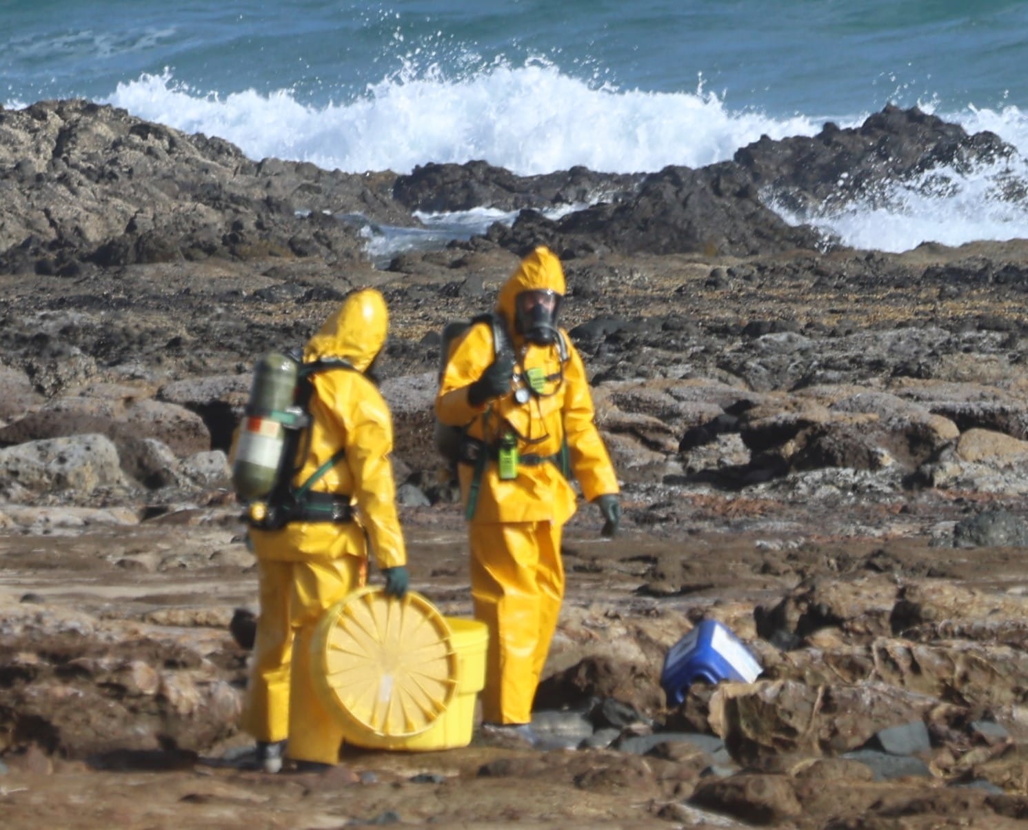 The HAZMAT team gets set to put the potentially hazardous drum of phosphoric acid in a containment bin.
