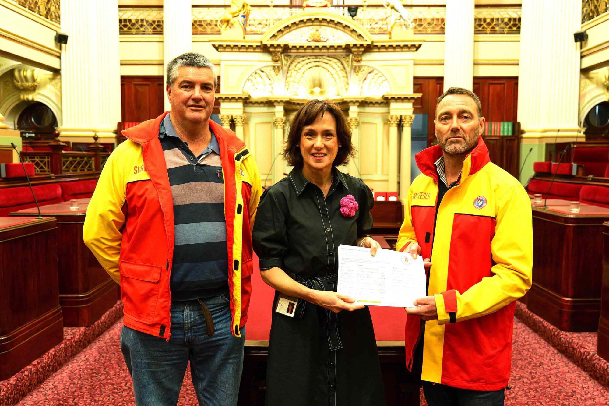 Glenn Arnold Inverloch SLC, Melina Bath MP and Stephen Duncan Inverloch SLC at the presentation of the ‘Save the Surf Club’ petition in State Parliament this week.