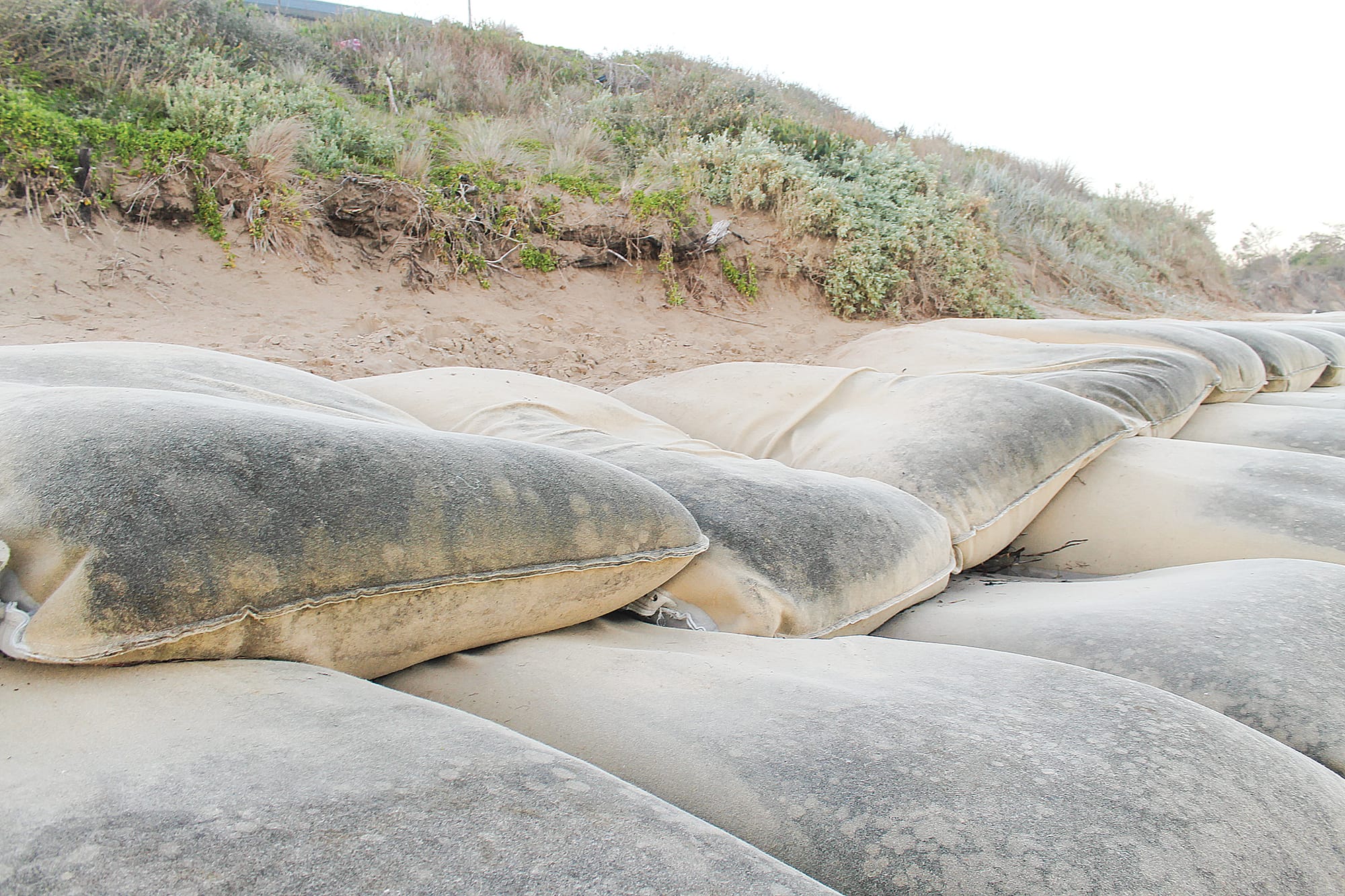 Contractors plan to work through the night to repair the damage to geotextile sandbags at the Inverloch SLSC. B22_2525