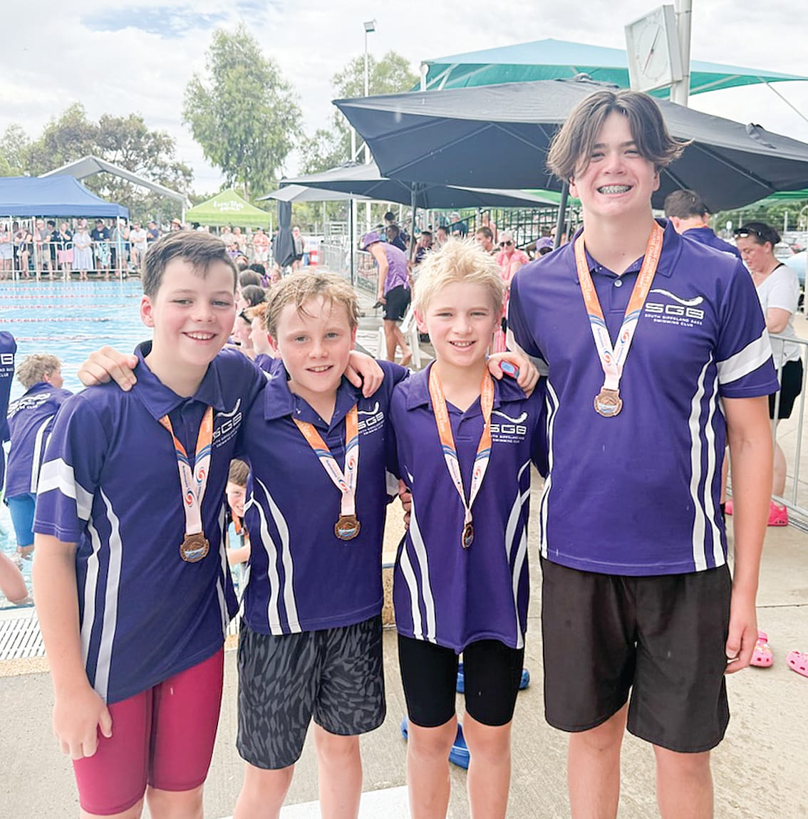 The 12 and under boys show off their third place in the medley relay.