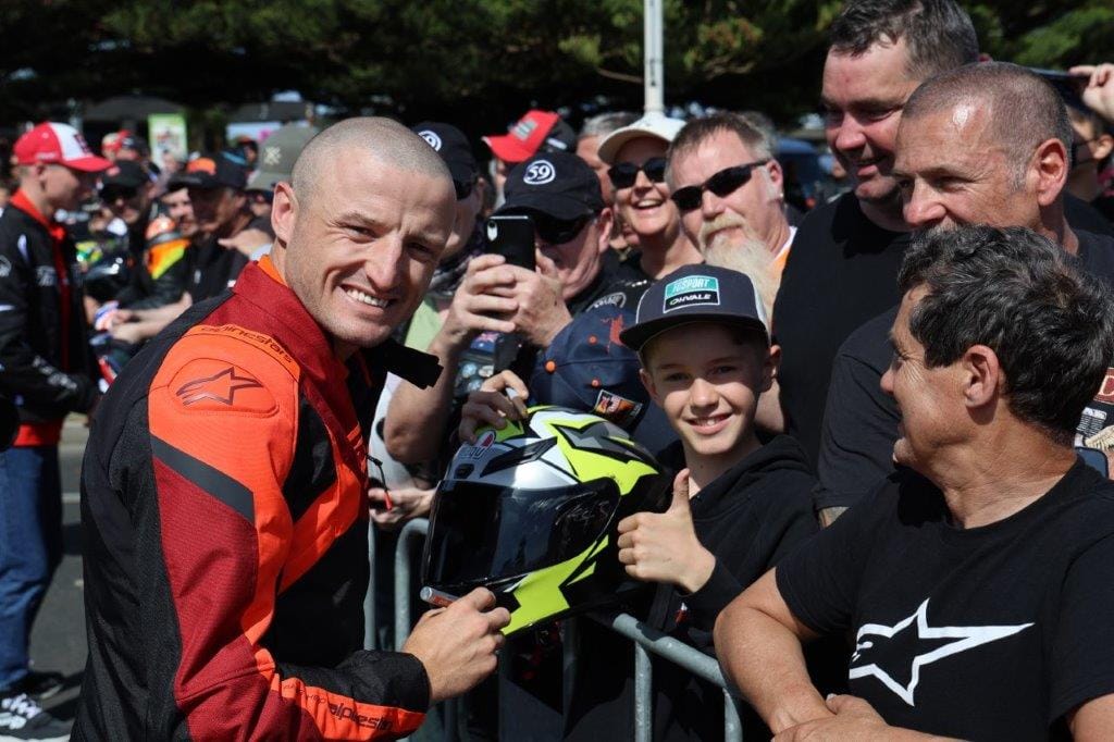 Aussie racer Jack Miller makes Melbourne visitor Cooper Horne’s day with an autograph.