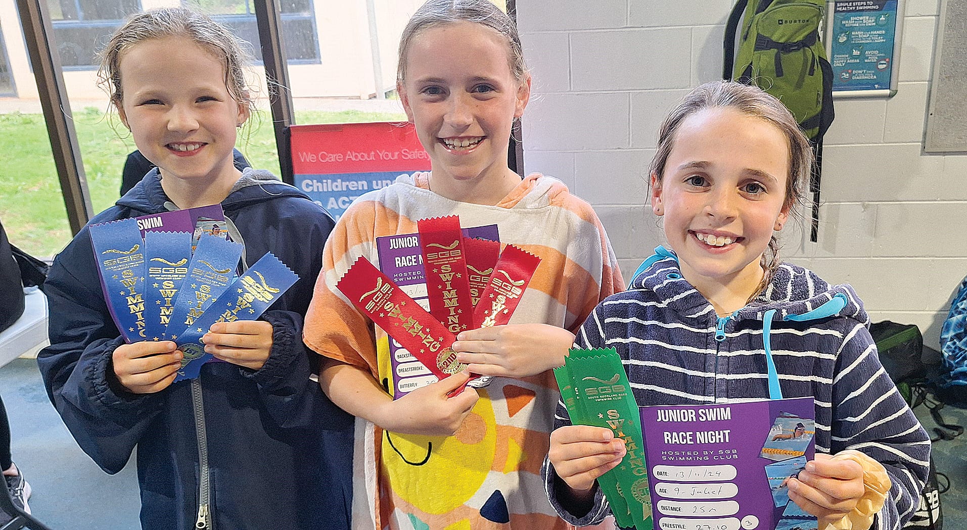 Mya, Grace and Juliet celebrate their efforts in the pool at Junior Race Night in Wonthaggi.