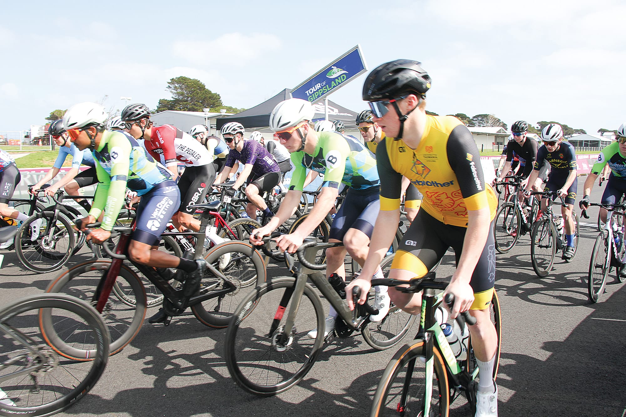 Van D’am racing team (green & blue) moving into position for the first day’s racing at Phillip Island in the Tour of Gippsland. B16_4124