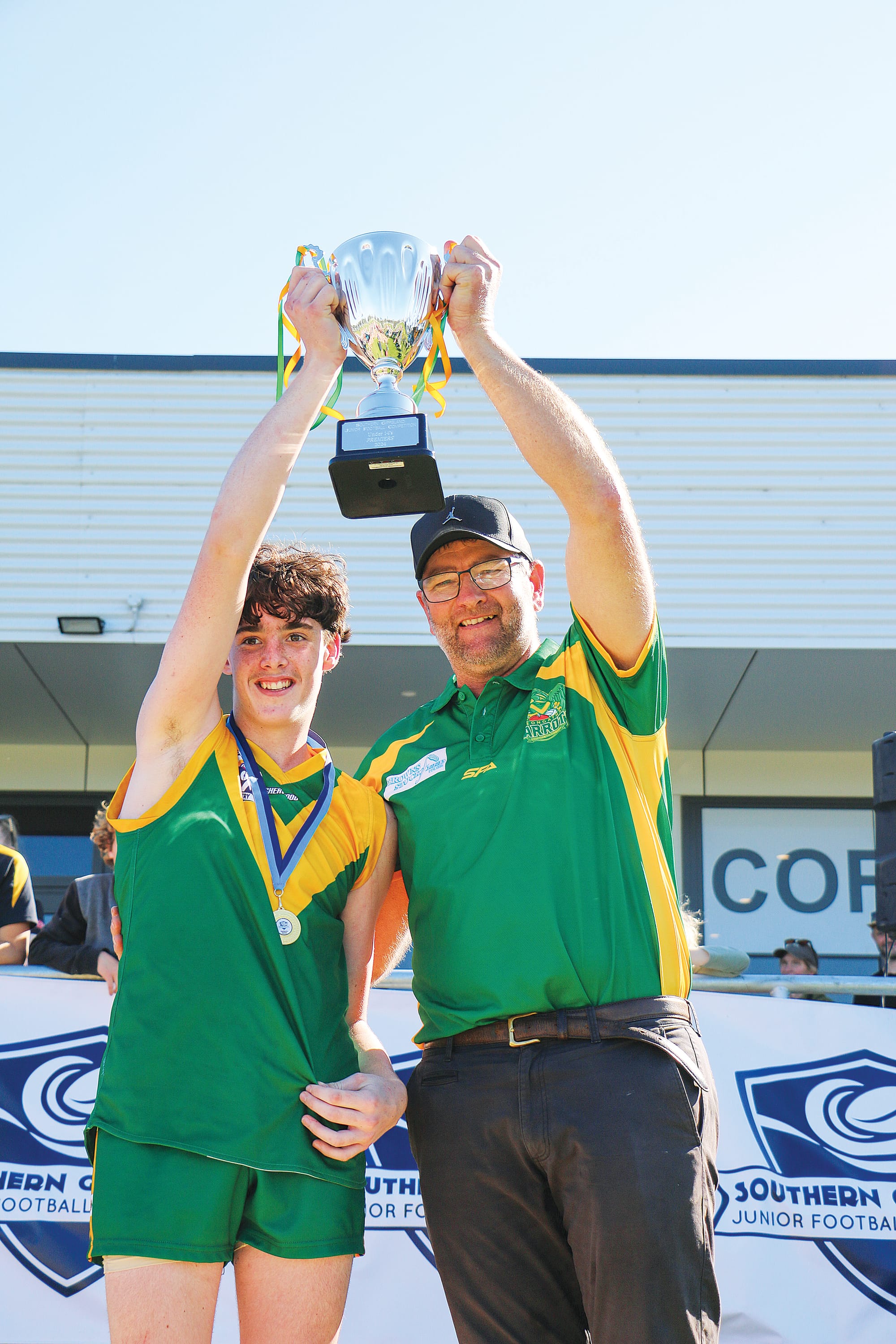 Leongatha captain Beau Elkin and coach Stuart Mackie hold up the U14 mixed premiership cup.