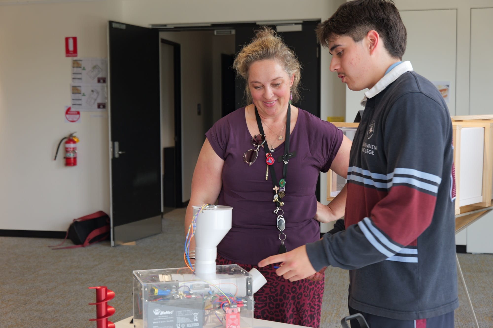VCE Systems Engineering student Santiago Leys explains his automated chicken feeding device to an interested parent.