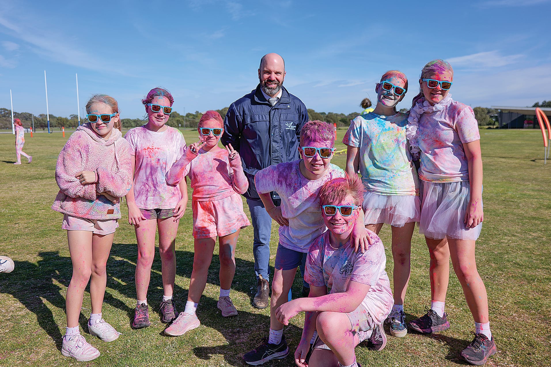 Middle School students covered in colour, pictured with teacher Lachlan Gale.