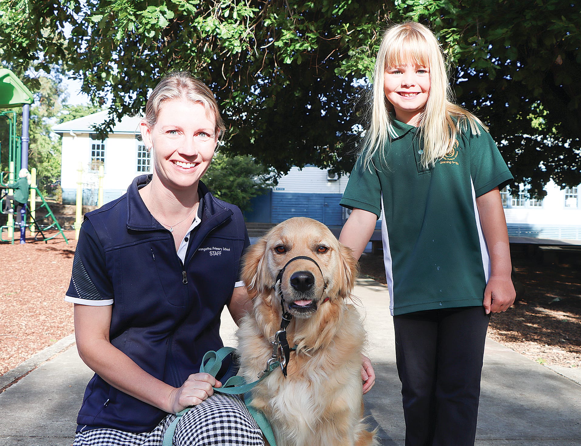 Teacher Michelle Hughes with school therapy dog Millie and Grade 2 student Heidi. A04_0525