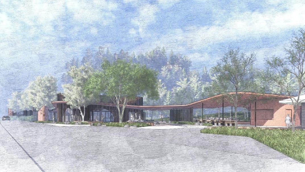 View from memorial of whole visitor area, including toilets to the right, covered seating and uplifted visitor centre.