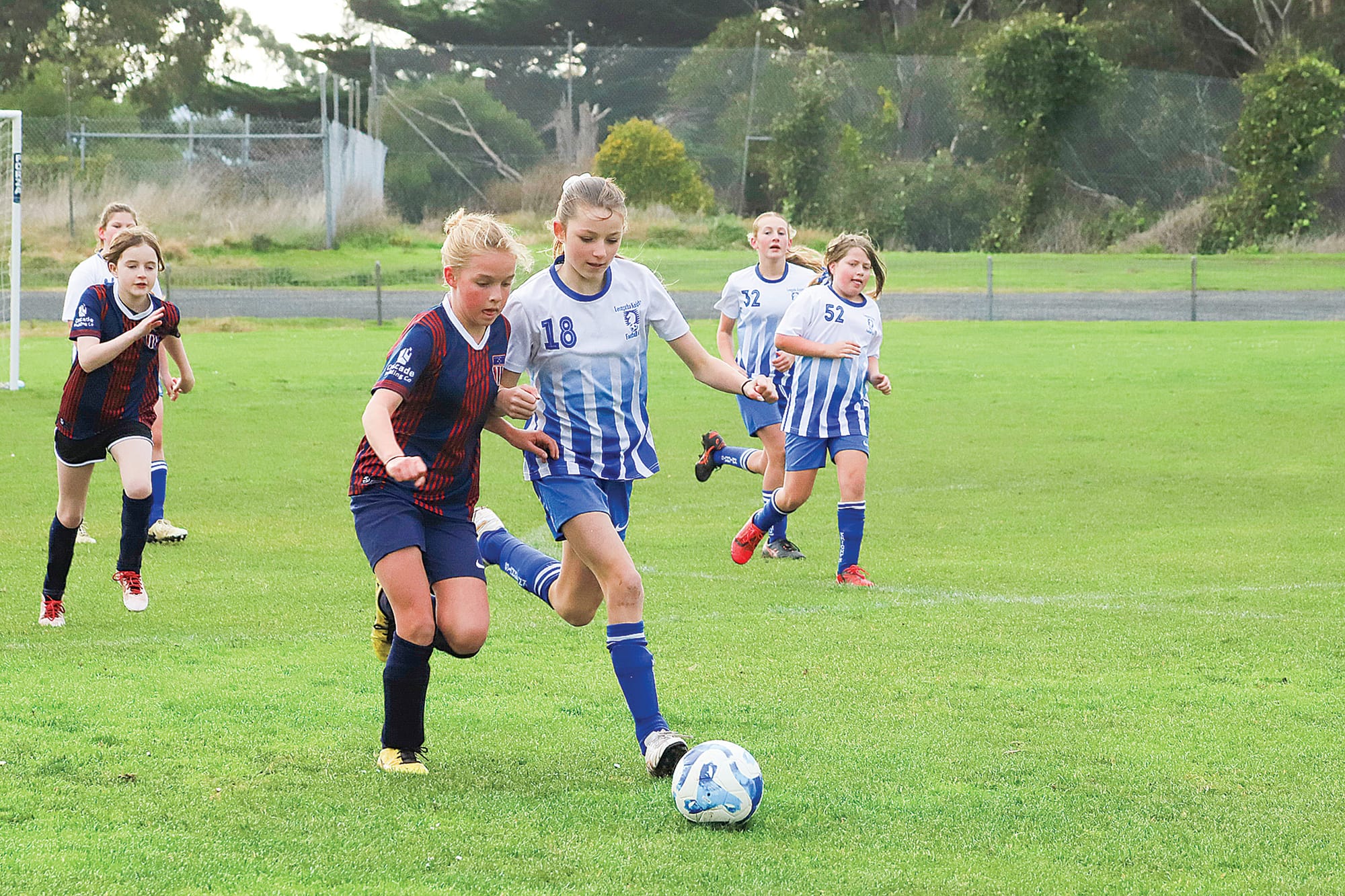 Leongatha’s Summer takes on the Korumburra Striker for possession of the ball in the U12 Girls. 
