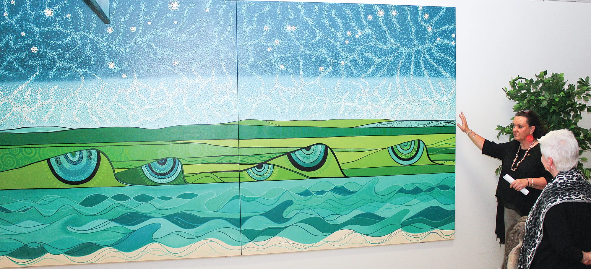 Artist Aunty Patrice Mahoney OAM explains her artwork’s representation of the sky and the land of the Bass Coast, watched by BCH CEO Jan Child. This artwork is on display in Grabham Wing, near Dialysis.