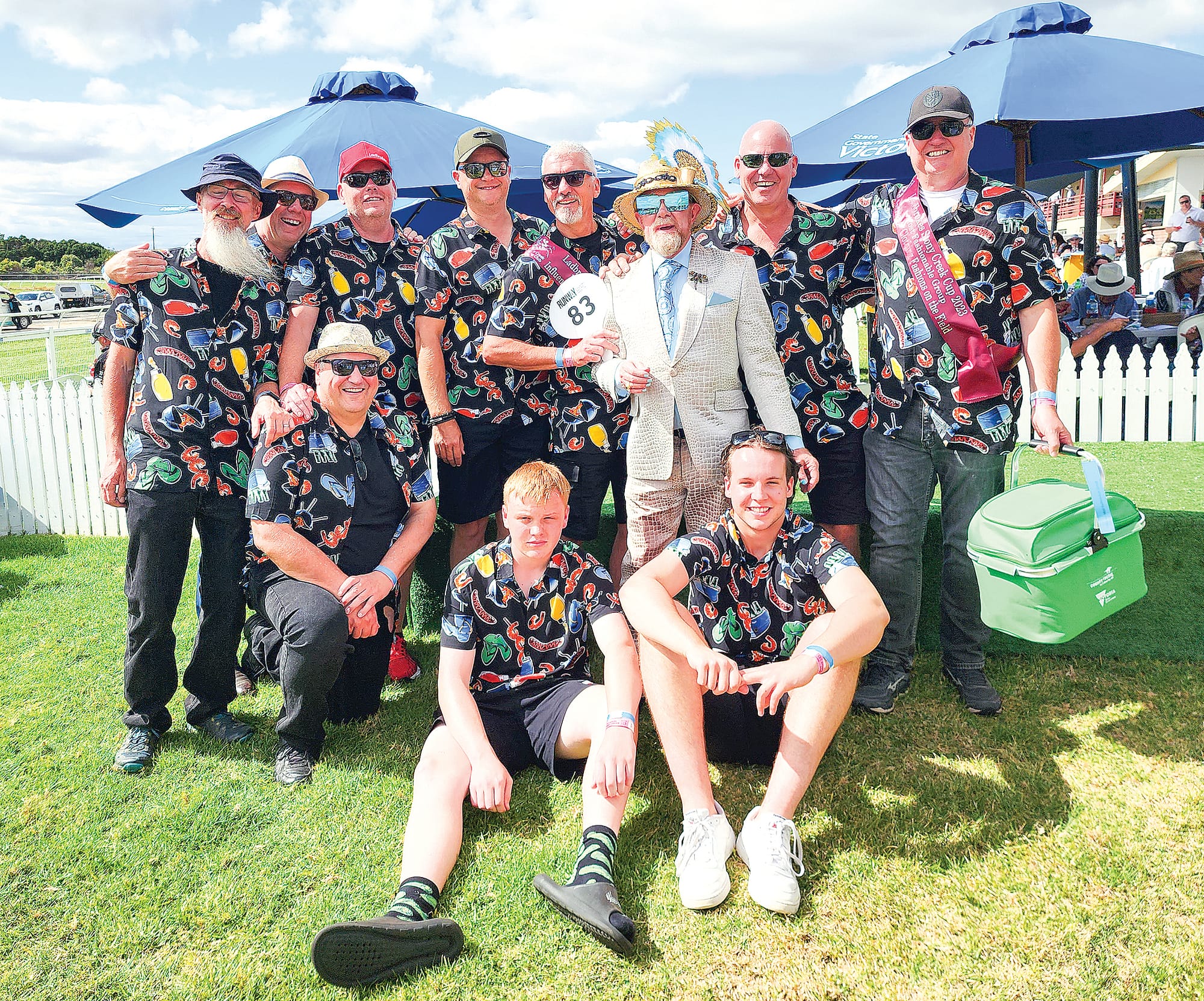 Judge Peter Jago jumps in with the winning Fashions on the Field Most Fashionable Group – the BBQ Blokes, who were at the races celebrating a bucks party. C43_1123