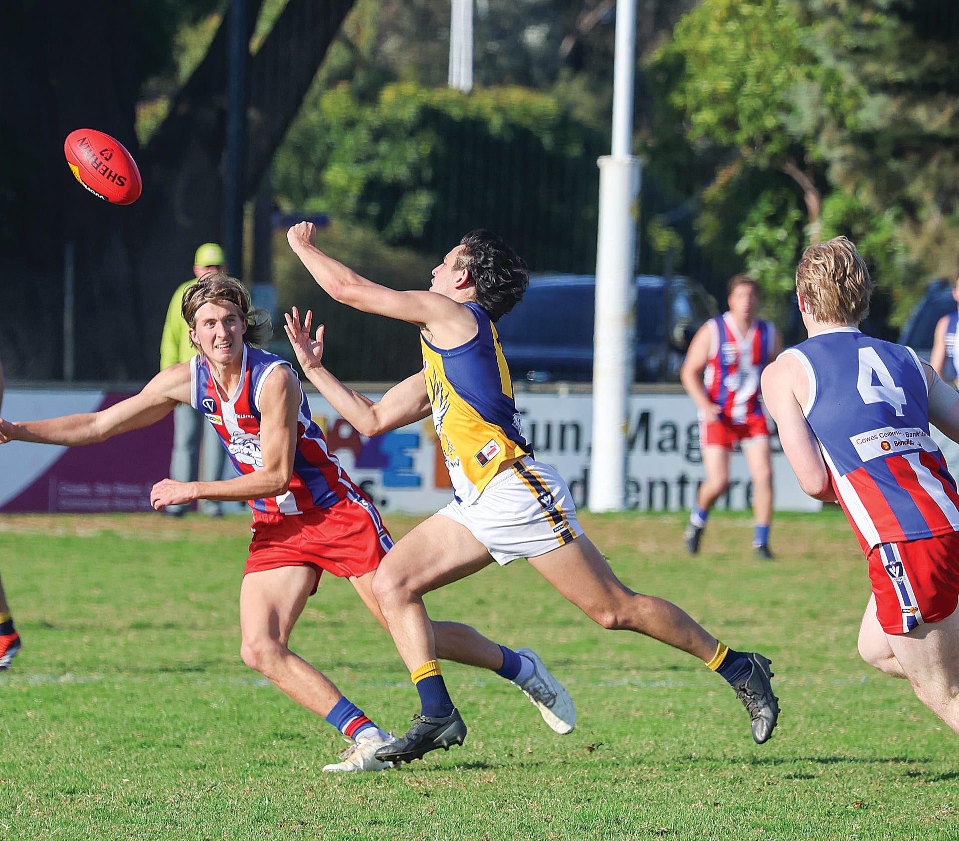 Inverloch-kongwak’s Nick Baltas is on the move away from this stoppage getting the ball going his team’s way under plenty of pressure from Phillip Island in brilliant sunshine at Cowes.