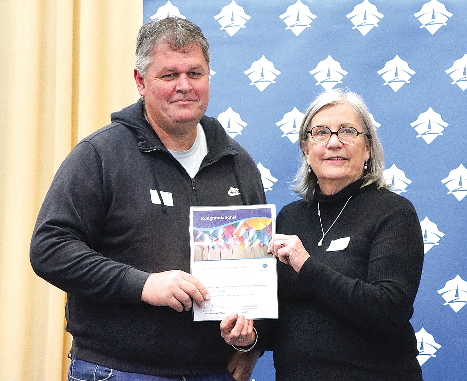 Sean Fraser of the Walter J Tuck Reserve Committee of Management collects $7500 to help with the purchase of a small tractor and mower, with Cr Mohya Davies. A16_3123