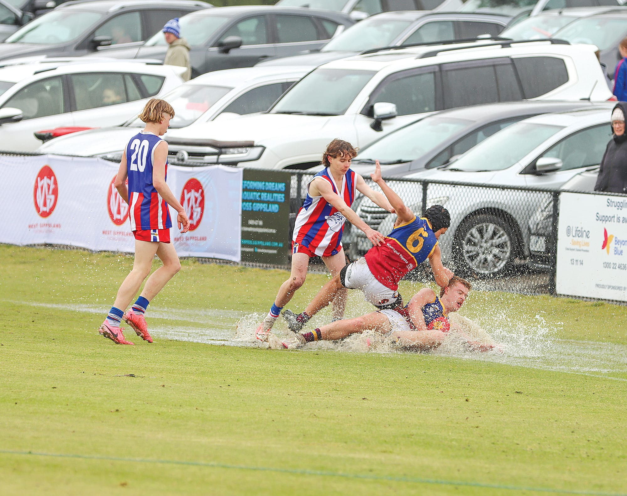 Phillip Island and Warragul Industrials players compete fiercely in the wet during Saturday’s Under 18s Grand Final won by the Bulldogs. A29_3824