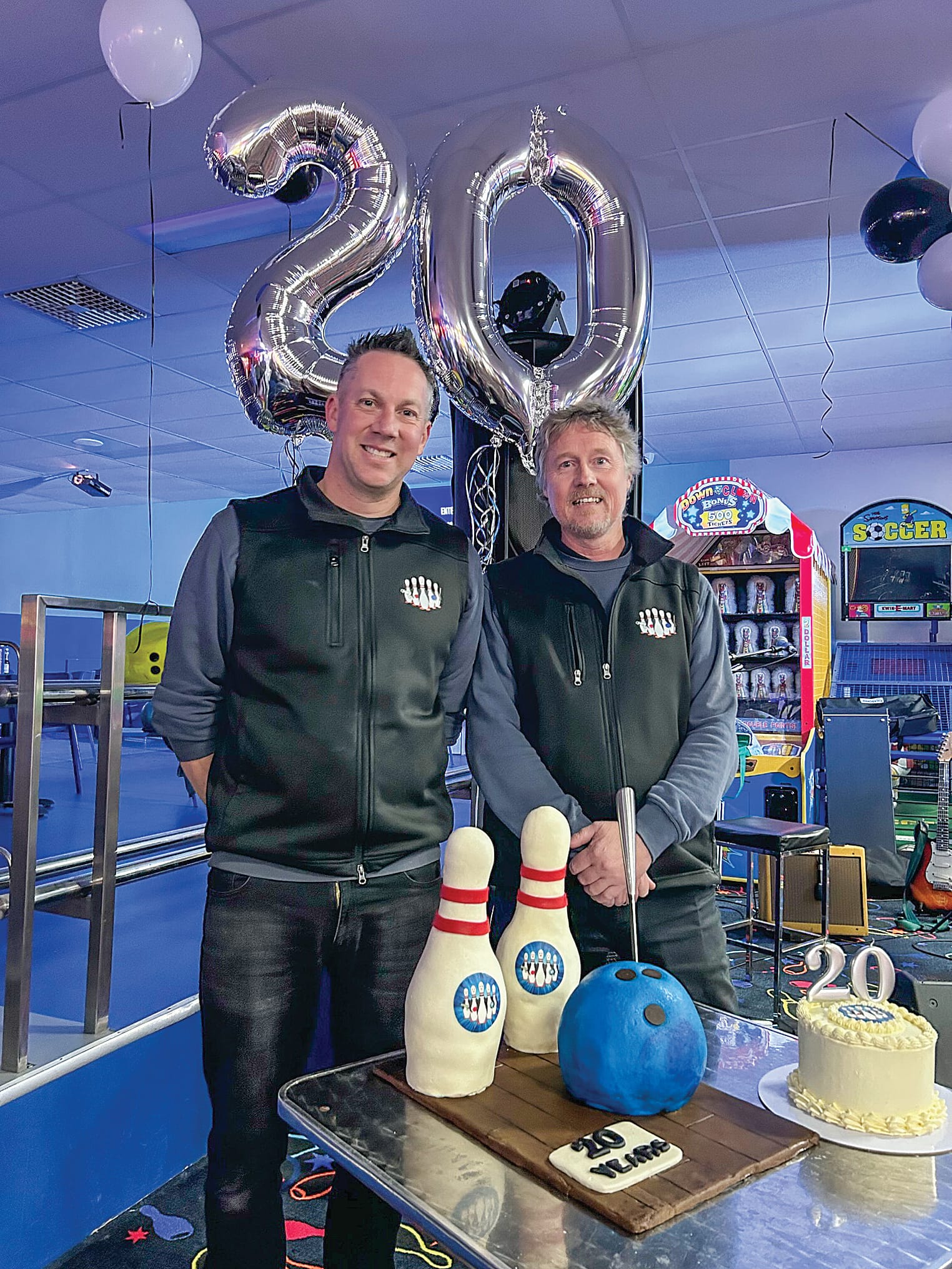 Craig and Jeremy celebrate 20 years cutting the cake. 
