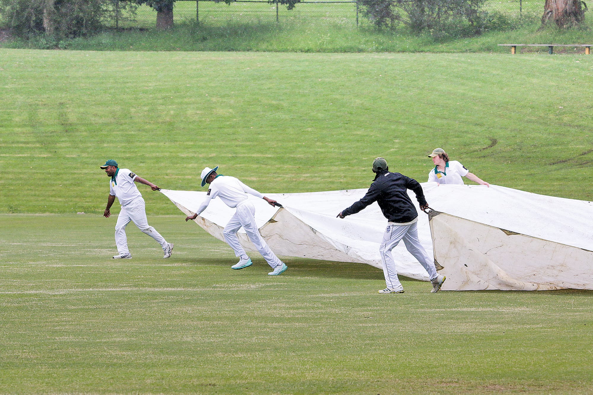 An all-too-familiar sight on cricket fields around Victoria this season, here the Leongatha Town A Grade players pull out the big cover as the rain gets heavier on Saturday afternoon.