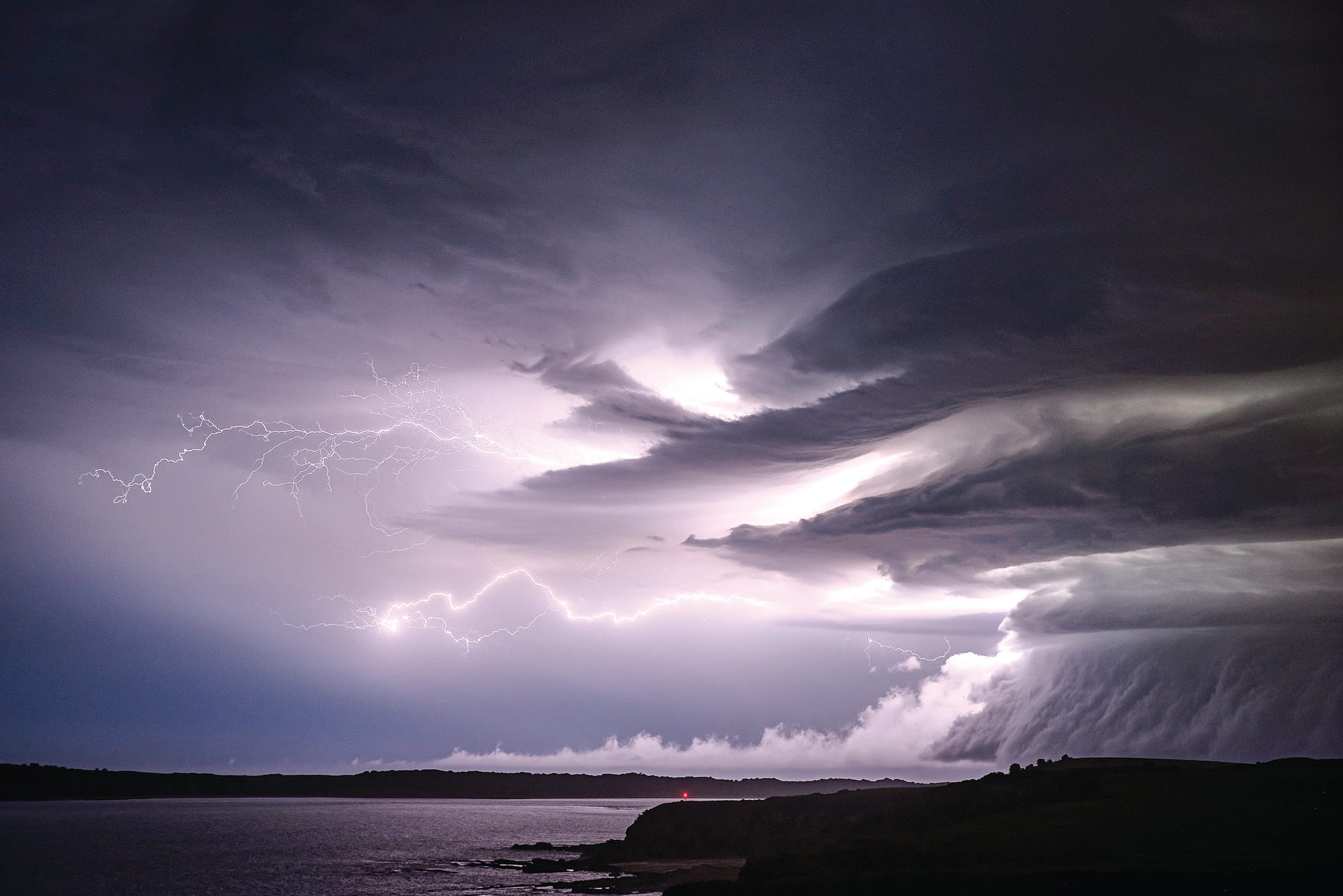 Bolts of lightning split the sky, illuminating a mesocyclone and defining an ominous supercell thunderstorm. Captured by production designer and night-time photographer Anna Carson, this stunning shot is featured in the Bureau of Meteorology’s 2025 Australian Weather Calendar. 