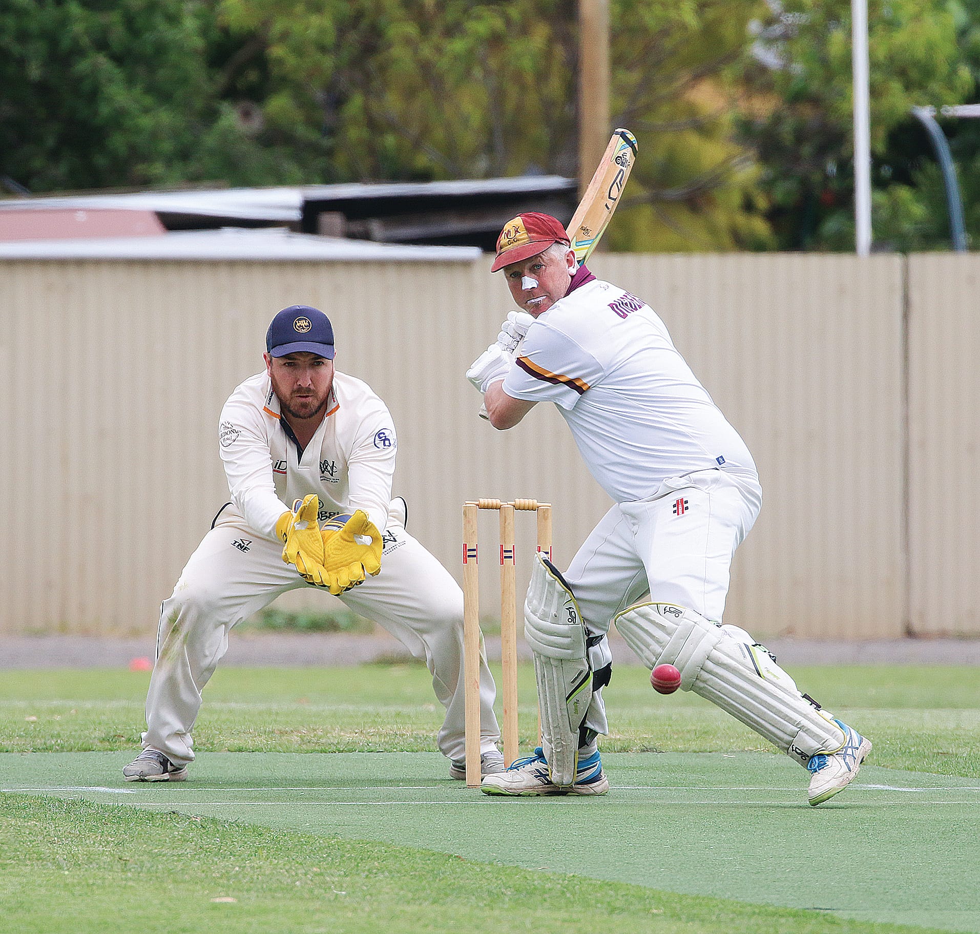 Club wicketkeeper Jack Sheerin and OMK batsman Russ White focus intently on the ball.
