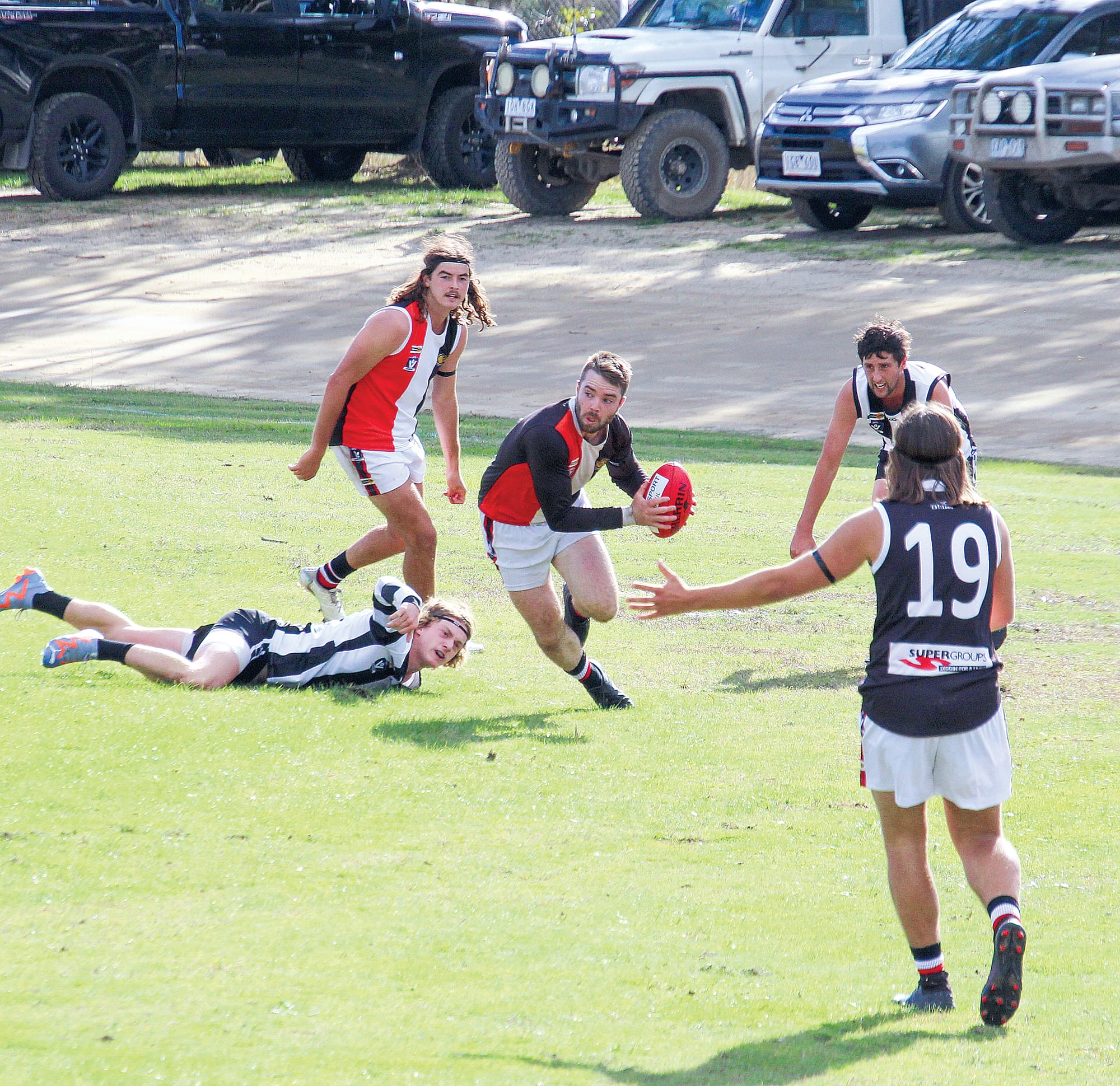 Nyora’s Dylan Heylen scrambles out with the ball as Poowong closes in. 