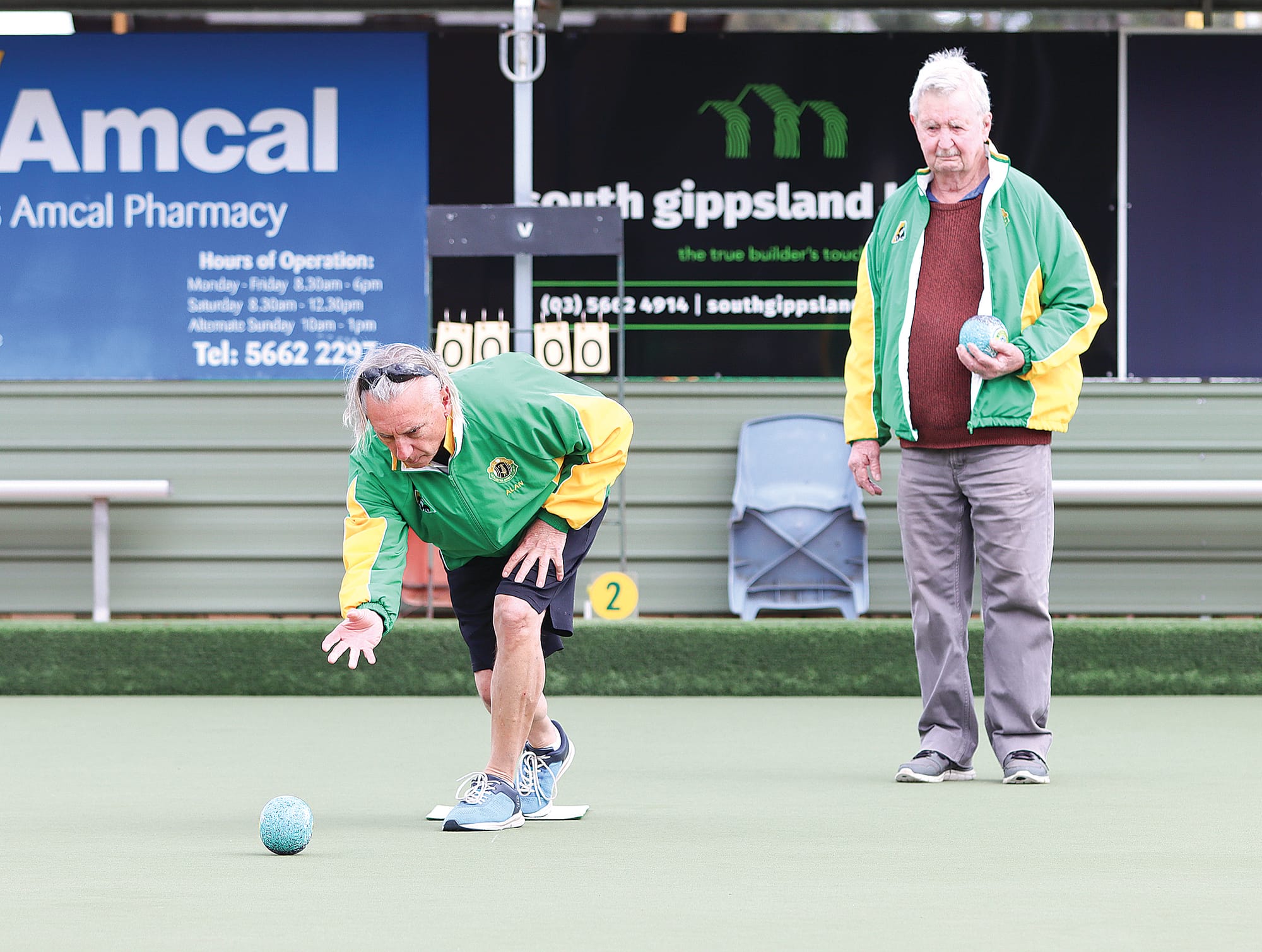 Coach Alan Center sends one down during a recent Monday roll-up session, while Jeff Pendergast looks on. A02_4625
